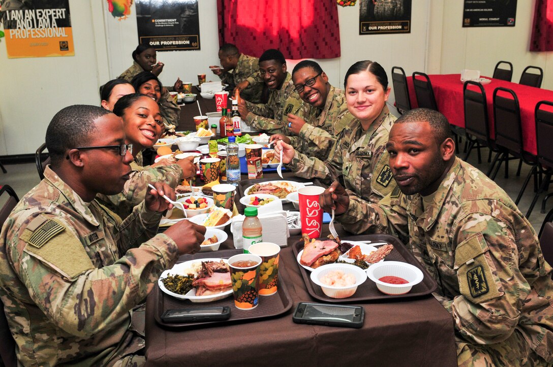 Service members sitting around a table eating Thanksgiving dinner