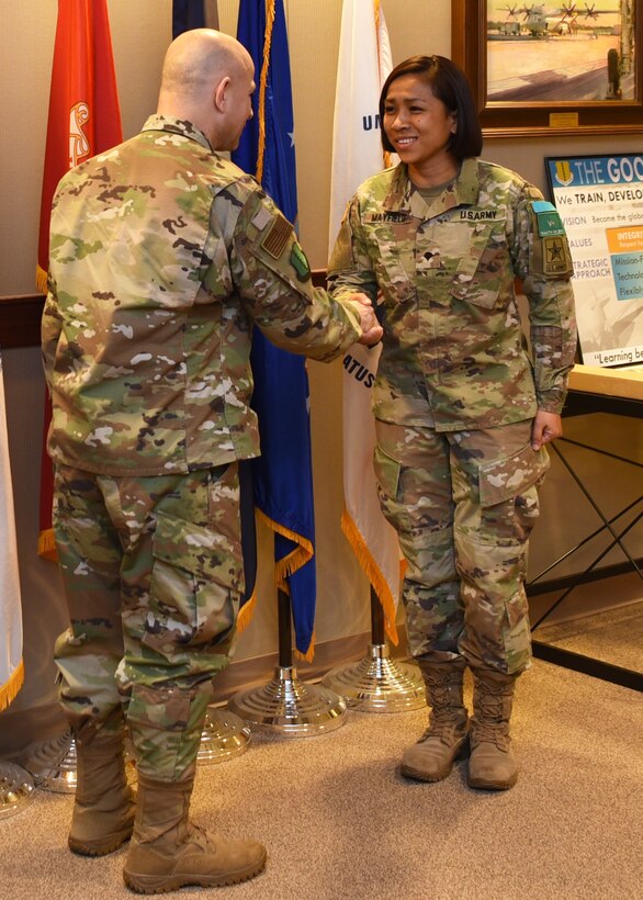 U.S. Air Force Col. Andres Nazario, 17th Training Wing commander, coins Army Specialist Karen Mayfield, 344th Military Intelligence Battalion student, at the 17th TRW Stand Up meeting inside the Norma Brown building on Goodfellow Air Force Base, Texas, Jan. 21, 2019.  Mayfield demonstrated excellence by volunteering over 400 hours while waiting over a year and a half for her security clearance approval. (U.S. Air Force photo by Airman 1st Class Abbey Rieves)