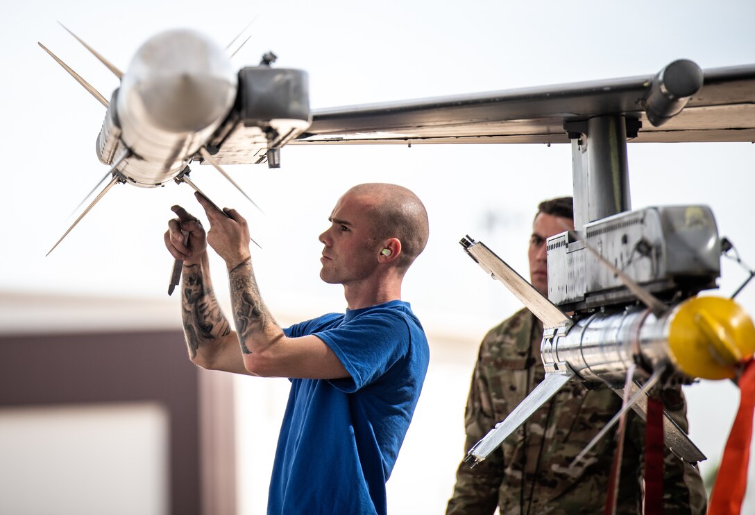 Senior Airman Sean Warden, 309th Aircraft Maintenance Unit weapons load crew member, inspects an inert AIM-120 missile as Senior Airman Nicholas Hyatt, 309th AMU, load crew leader, reviews his performance during the Annual Load Crew Competition Jan. 24, 2020, at Luke Air Force Base, Ariz.