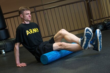 Army Maj. Timothy Benedict, an Army Public Health Center physical therapist, uses a foam roller massager to improve muscle tissue recovery following his workout.
