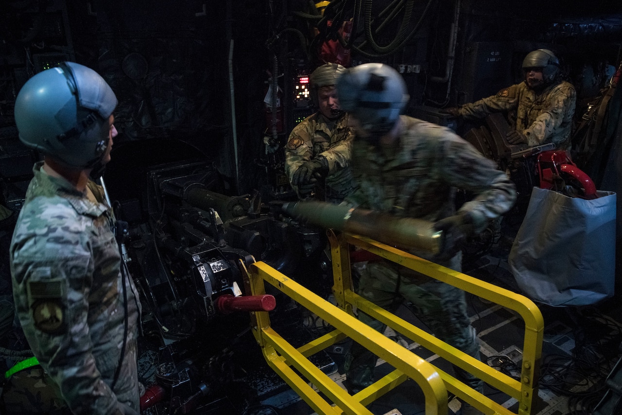 Airmen load cannon on plane.