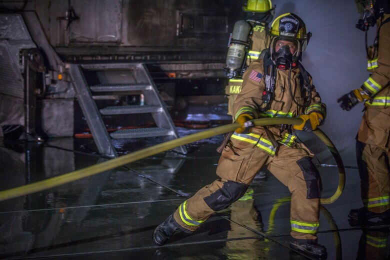 U.S. Marines with Aircraft Rescue and Firefighting (ARFF), Headquarters and Headquarters Squadron (H&HS), Marine Corps Air Station (MCAS) Yuma conduct low light hand line drills during live burn training on MCAS Yuma, Ariz., Nov. 21, 2019. Hand line drills focus on techniques to push fuel fires away from aircraft, ARFF Marines train monthly to enhance their readiness when responding to emergencies on the flight line. (U.S. Marine Corps photo by Lance Cpl John Hall)