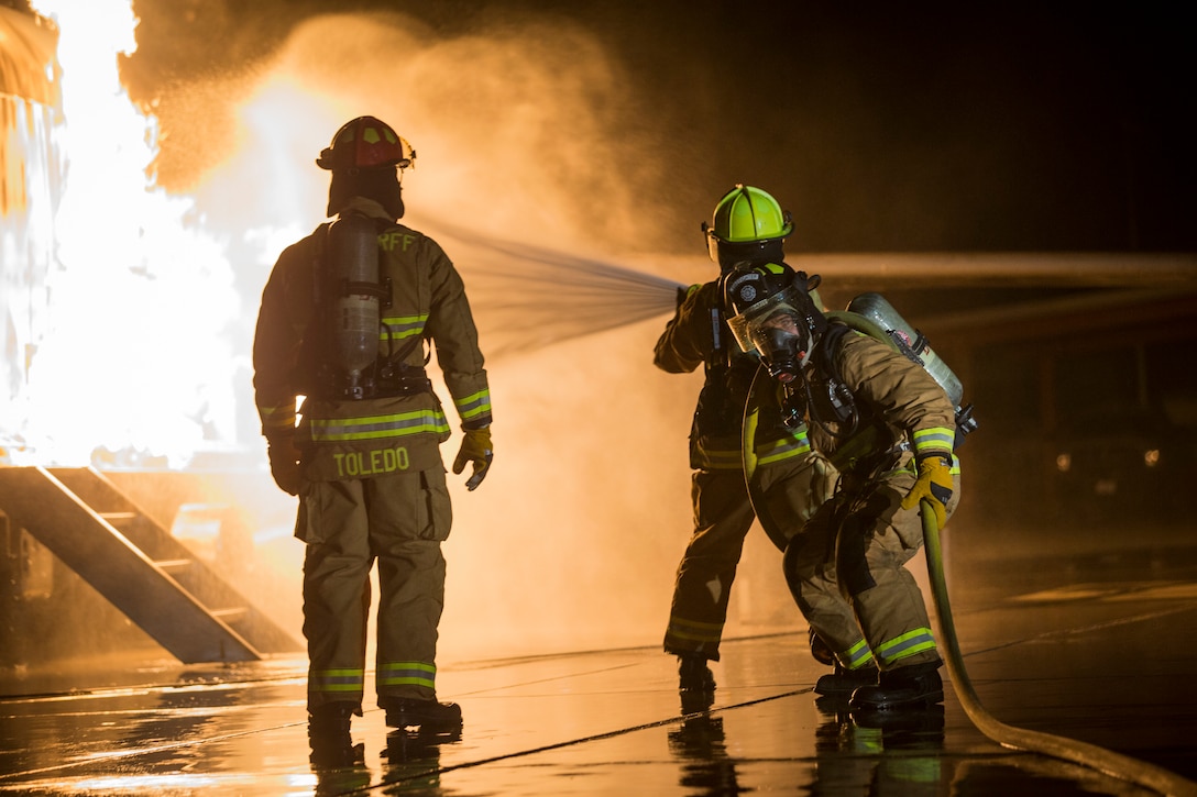 U.S. Marines with Aircraft Rescue and Firefighting (ARFF), Headquarters and Headquarters Squadron (H&HS), Marine Corps Air Station (MCAS) Yuma conduct low light hand line drills during live burn training on MCAS Yuma, Ariz., Nov. 21, 2019.