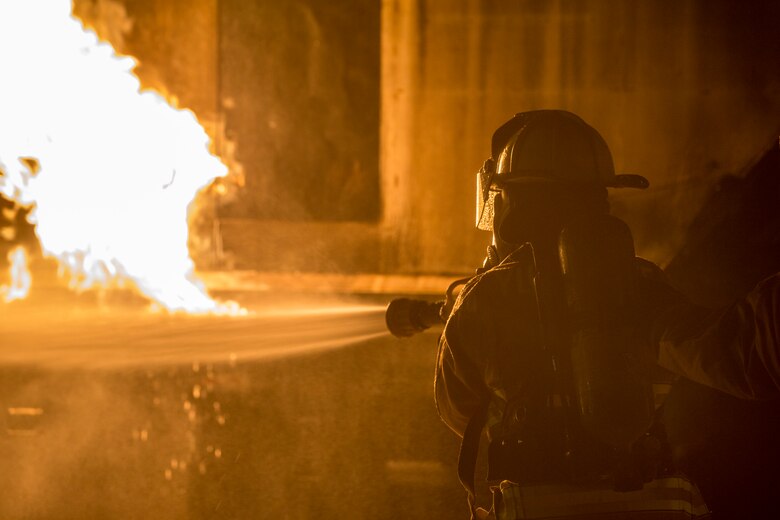 U.S. Marines with Aircraft Rescue and Firefighting (ARFF), Headquarters and Headquarters Squadron (H&HS), Marine Corps Air Station (MCAS) Yuma conduct low light hand line drills during live burn training on MCAS Yuma, Ariz., Nov. 21, 2019. Hand line drills focus on techniques to push fuel fires away from aircraft, ARFF Marines train monthly to enhance their readiness when responding to emergencies on the flight line. (U.S. Marine Corps photo by Lance Cpl John Hall)