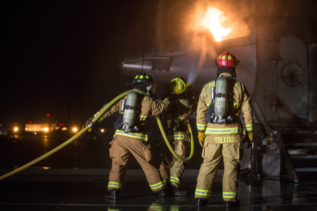 U.S. Marines with Aircraft Rescue and Firefighting (ARFF), Headquarters and Headquarters Squadron (H&HS), Marine Corps Air Station (MCAS) Yuma conduct low light hand line drills during live burn training on MCAS Yuma, Ariz., Nov. 21, 2019.