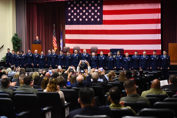 Specialized Undergraduate Pilot Training Class 20-06/07 stands in front of an audience at the Kaye Auditorium following their graduation ceremony Jan. 24, 2020, on Columbus Air Force Base, Mississippi. SUPT consists of a year of pilot training in the T-6 Texan II followed by either the T-38 Talon if the pilot is going to fly fighter or bomber aircraft or the T-1 Jayhawk if the pilot is flying cargo or tanker aircraft. (U.S. Air Force photo by Airman 1st Class Jake Jacobsen)