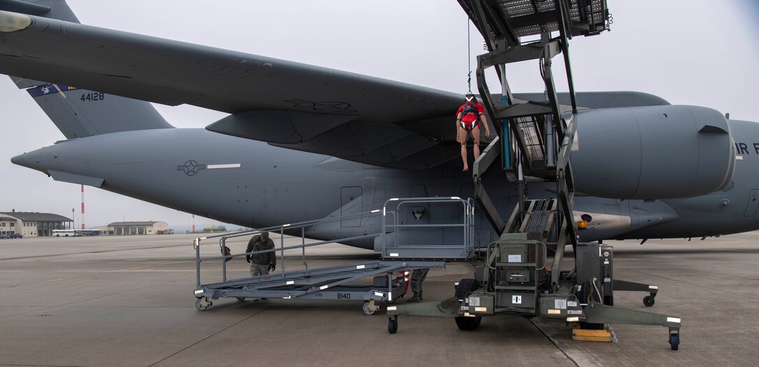 U.S. Air Force Staff Sgt. Michael Morrissey, 726th Air Mobility Squadron electrical and environmental systems craftsman, right, and Senior Airman Billy Meyer, C-17 instrument and flight control system journeyman, left, position an aircraft maintenance lift to rescue a training dummy during a fall protection exercise at Spangdahlem Air Base, Germany, Jan. 23, 2020. The Airmen had to successfully perform the rescue within six minutes to satisfactorily complete the training. (U.S. Air Force photo by Senior Airman Kyle Cope)