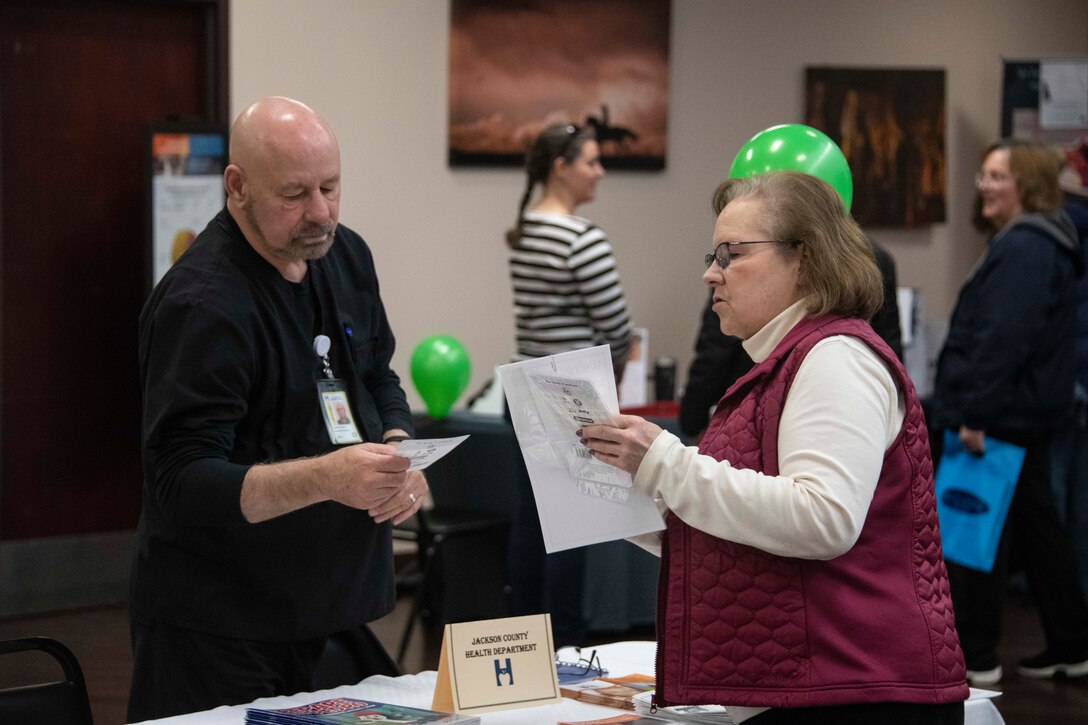 Gayle Kenyon, the health promotion coordinator assigned to the 97th Operational Medical Readiness Squadron, talks to a facilitator at Wellness Expo 2020