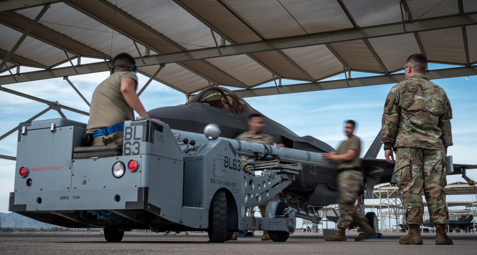 Load crew members assigned to the 62nd Aircraft Maintenance Unit move quickly to load an AIM-9X missile onto an F-35A Lightning II during the Annual Load Crew Competition Jan. 24, 2020, at Luke Air Force Base, Ariz.