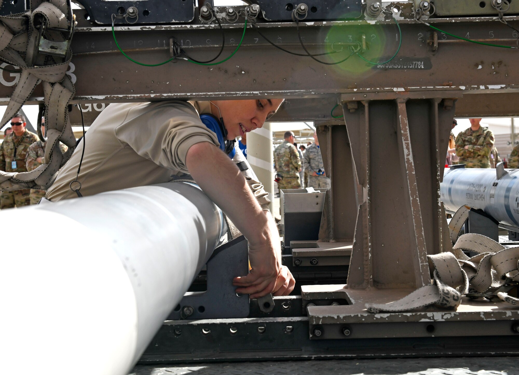 Senior Airman Dorothy Zurlinden, 61st Aircraft Maintenance Unit weapons load crew member, tightens a ratchet strap on an inert munition during the Annual Load Crew Competition Jan. 24, 2020, at Luke Air Force Base, Ariz.