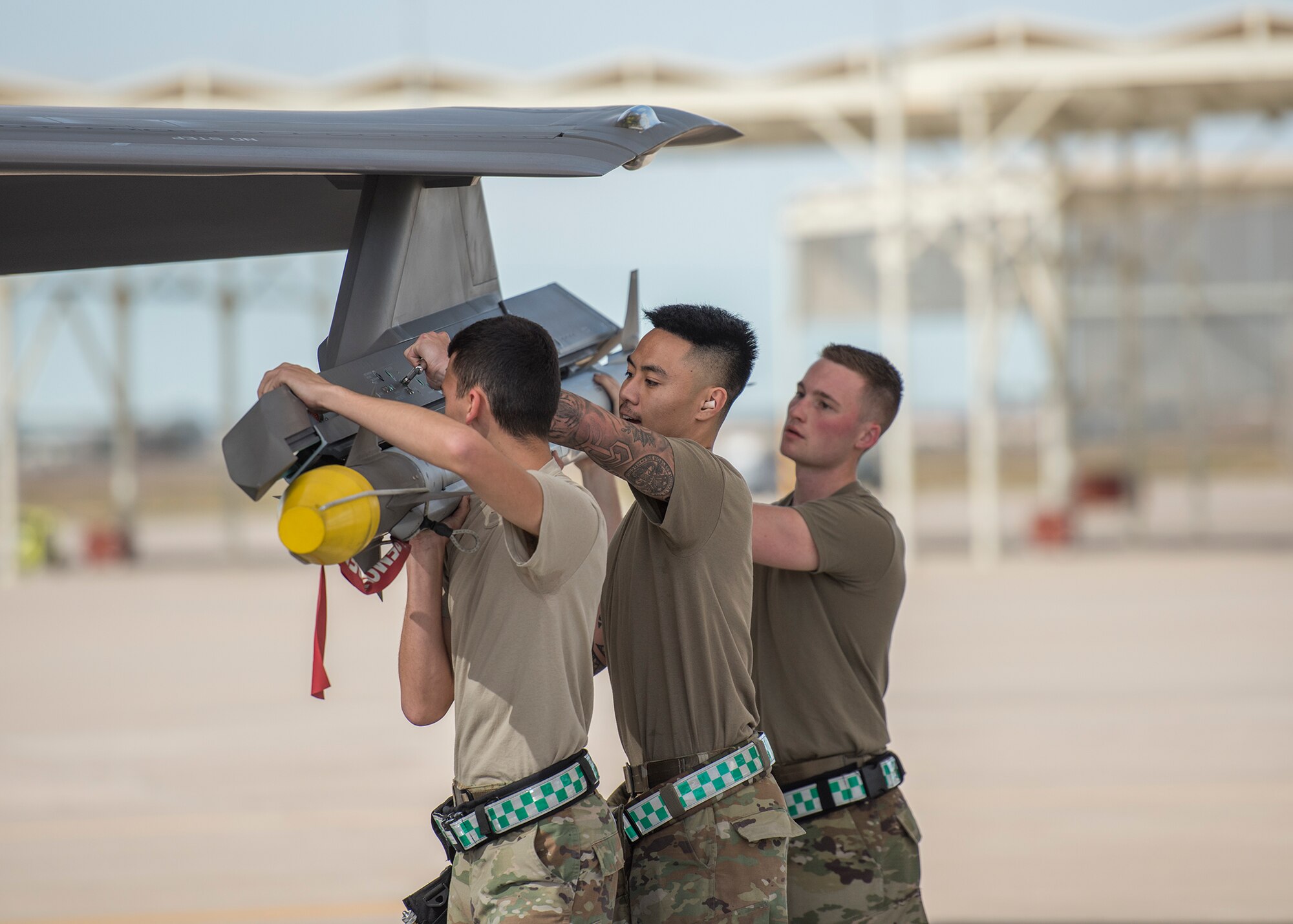 Airman 1st Class Daniel Kaleiwahea (left), Staff Sgt. Theodore Reyes and Senior Airman Alden West, 308th Aircraft Maintenance Unit weapons load crew team, load an inert munition onto an F-35A Lightning II during the Annual Load Crew Competition, Jan. 24, 2020, at Luke Air Force Base, Ariz.