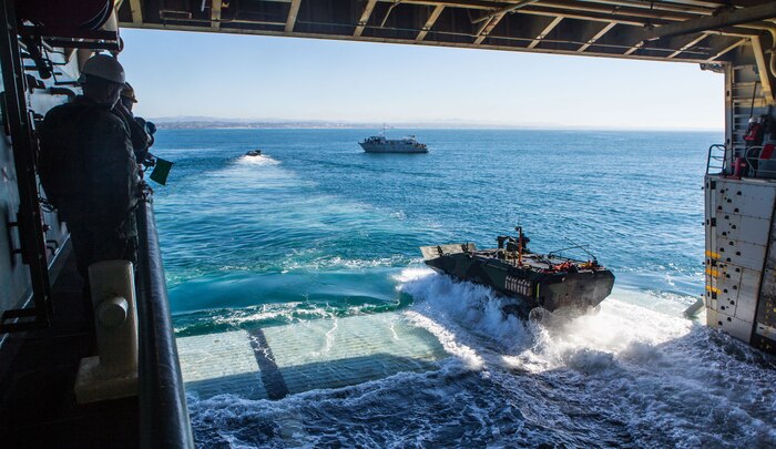 U.S. Marines and sailors observe as Marines assigned to Amphibious Vehicle Test Branch, Marine Corps Tactical Systems Support Activity, maneuver an amphibious combat vehicle onto the well deck of the amphibious transport dock ship USS Somerset (LPD 25) as part of the vehicle’s developmental testing off the shore of Marine Corps Base Camp Pendleton, Calif., Jan. 28, 2020. The Marines of AVTB are currently testing the Marine Corps’ newest amphibious vehicle, which will replace the current amphibious assault vehicle. The testing consisted of entering and departing a naval vessel to assess and verify how well the ACV can integrate with naval shipping. This was the first time Marines have operated the new vehicle while boarding and departing a ship.