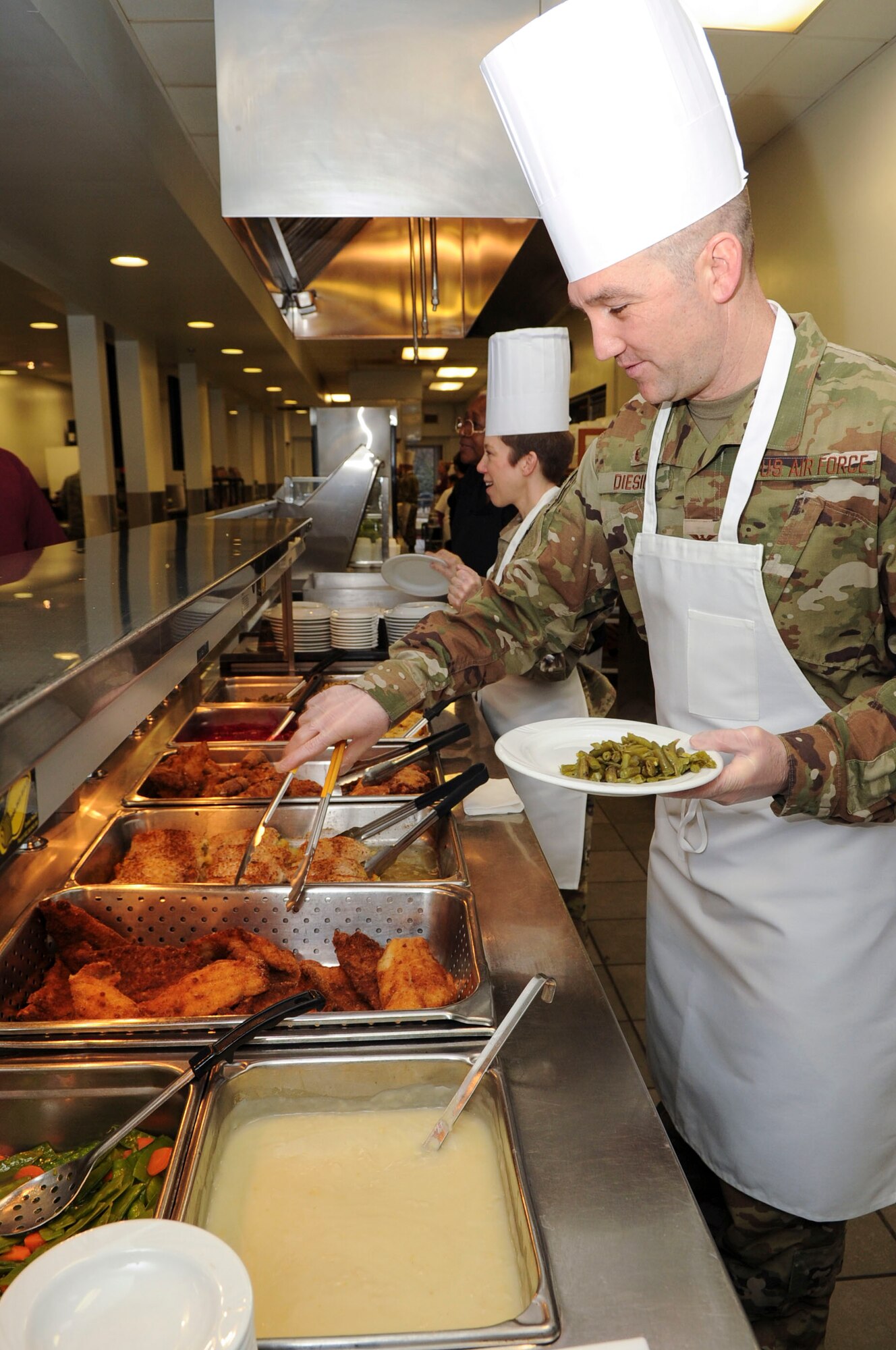 Col. Katherine Barber, Space, Missiles and Foreign Intelligence Group commander and Col. Duane Diesing, Global Exploitation Intelligence Group commander, serve food at the Pitsenbarger Dining Facility on Wright-Patterson Air Force Base, Ohio on Jan. 24, 2020. Barber and Diesing used their time at the dining facility as an opportunity to be active and visible in the lives of their Airmen and the base community.   (U.S. Air Force photo Staff Sgt. Seth Ray Stang)