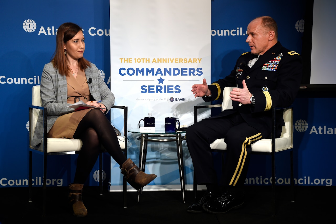 A man and woman sit facing each other across a small table.