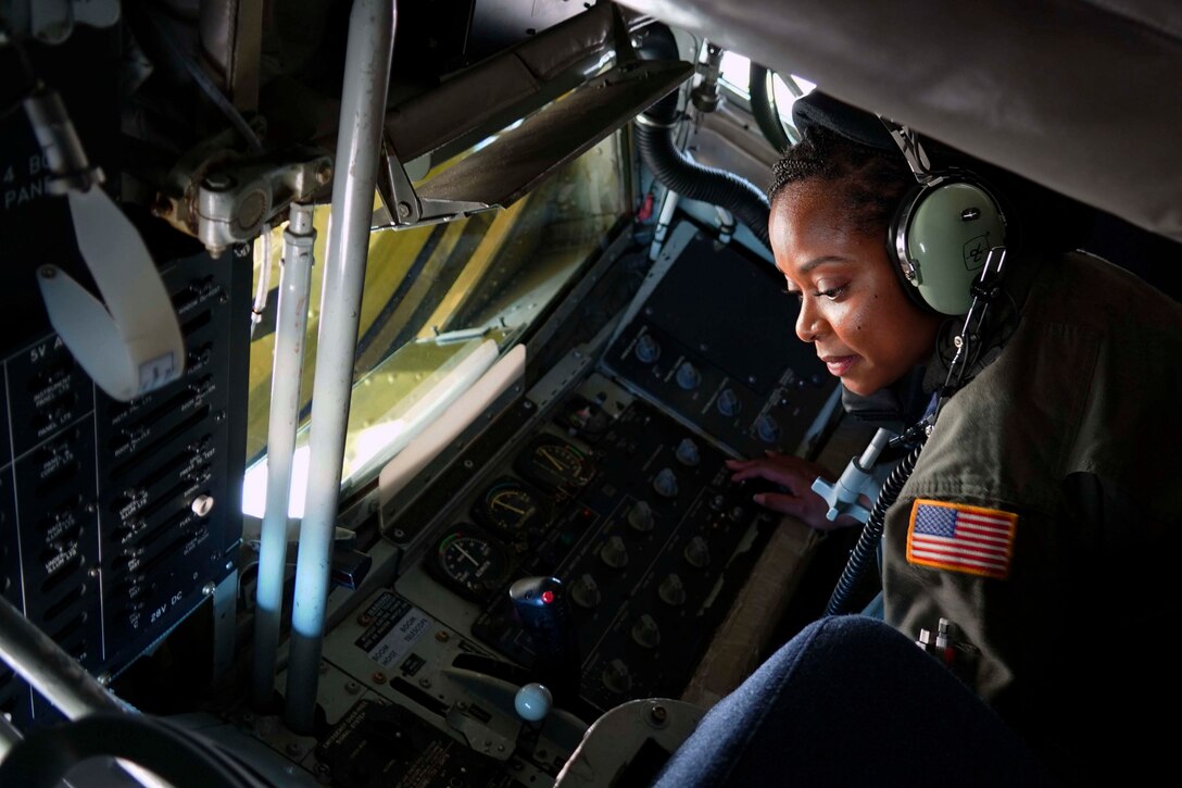 An airman sits inside of an aircraft.
