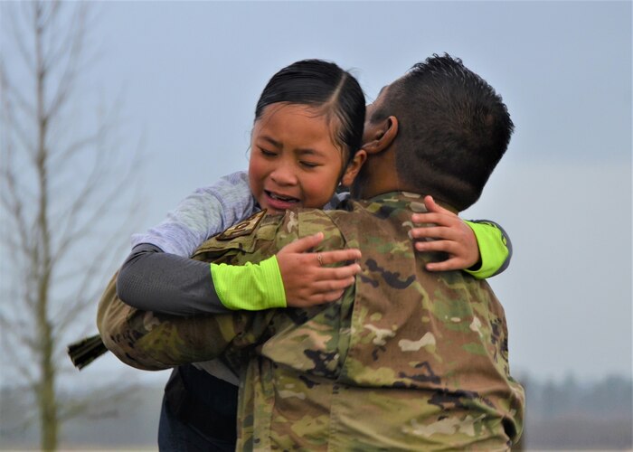 Tech. Sgt. Russell Dela Montanye of the 446th Logistics Readiness Flight hugs his daughter, Celine, during a surprise homecoming on the finish line of a 5K race hosted by I Corps and the 62nd Airlift Wing Jan. 24 to commemorate the life and legacy of Dr. Martin Luther King Jr. at Joint Base Lewis-McChord. (U.S. Army photo by Nathan Wilkes)