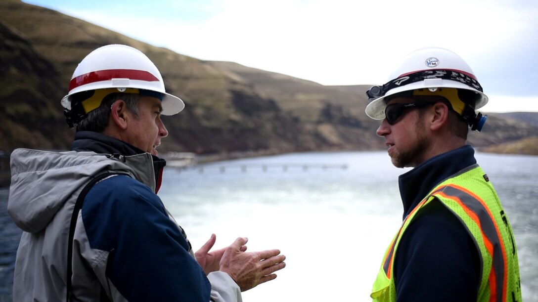 Two men talking about spillway PIT tags at Lower Granite Dam.