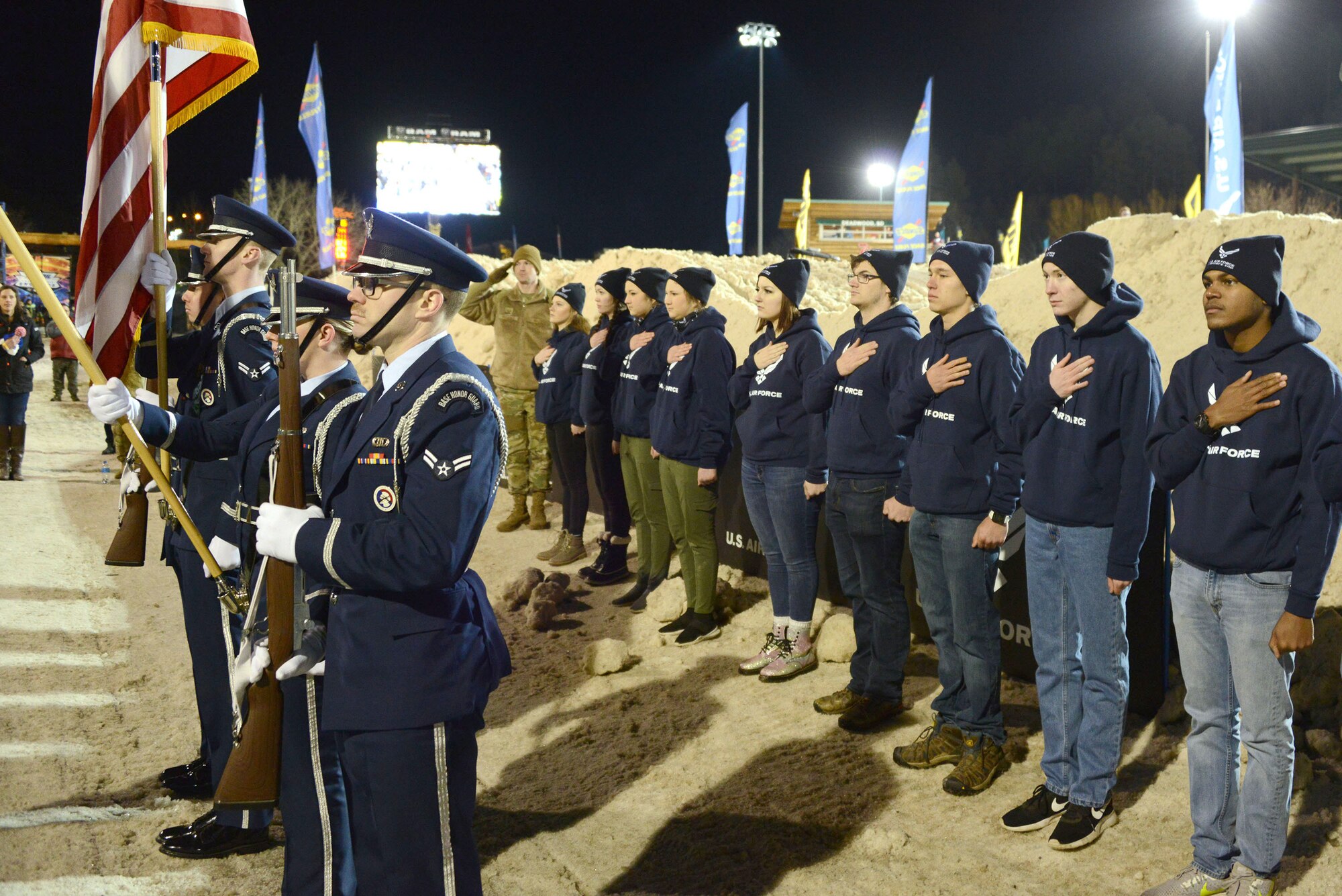 The Air Force Honor Guard team from Ellsworth Air Force Base, South Dakota and 18 new enlistees pay respect to the flag during the U.S. Air Force Snocross National in Deadwood, South Dakota.