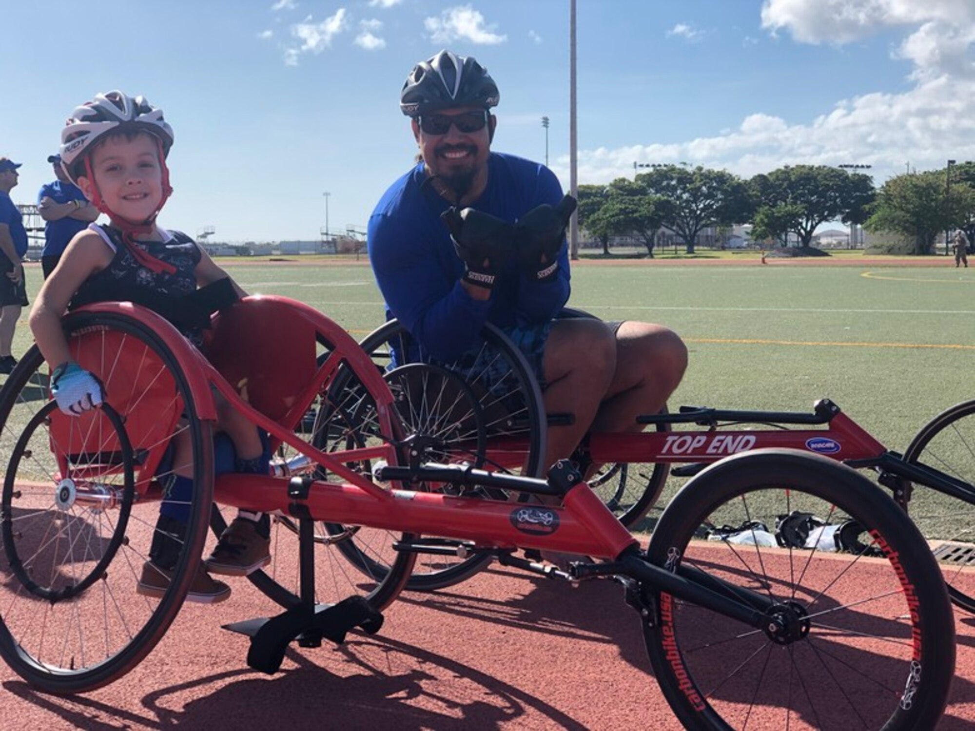 Tucker Hall, a four year old with Spina Bifida, gets ready to race Chief Master Sgt. retired Garrett Kuwada, Air Force Wounded Warrior Program athlete and Team US Invictus Games competitor, at the 2020 U.S. Pacific Air Forces Warrior CARE event, January 27, 2020 at Joint Base Pearl Harbor-Hickam. Tucker, the son of a volunteer at the event, was brought to the event to witness the service men and women who participate in the adaptive sports program and witness the resiliency of the warriors who do not let their illnesses or injuries define them. (Courtesy photo)