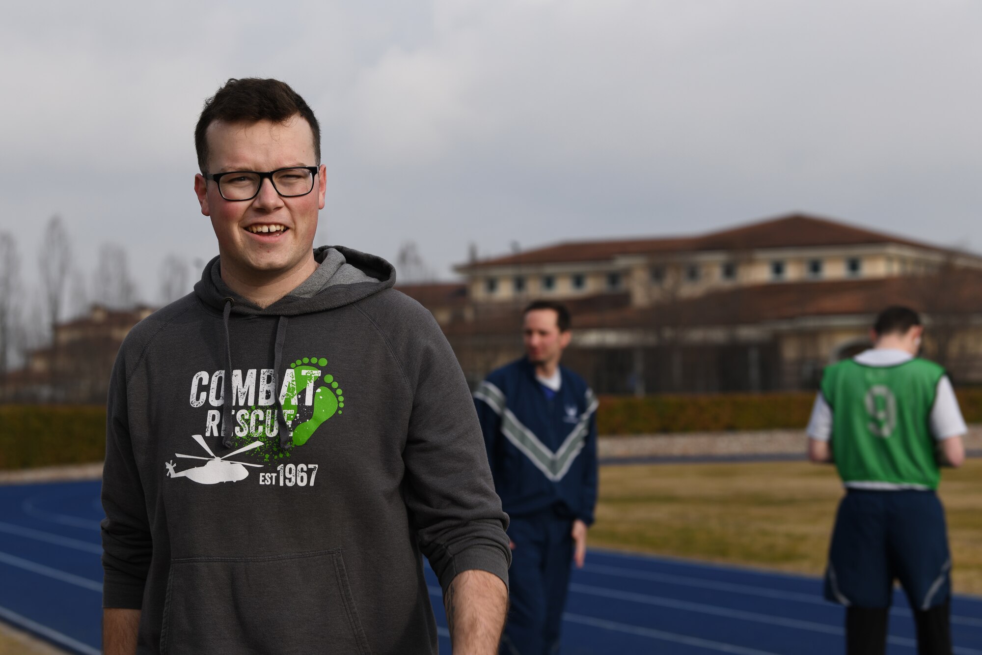 U.S. Air Force Airman 1st Class Dale Riehl, 31st Aircraft Maintenance Squadron, 56th Helicopter Maintenance Unit, helicopter tilt rotor maintainer, smiles as an Airmen from his unit gets ready to start their physical fitness assessment at Aviano Air Base, Italy, Jan. 27, 2019. Airmen who take a fitness assessment will receive a score in one of three categories: excellent, satisfactory or unsatisfactory. (U.S. Air Force photo by Airman 1st Class Ericka A. Woolever)