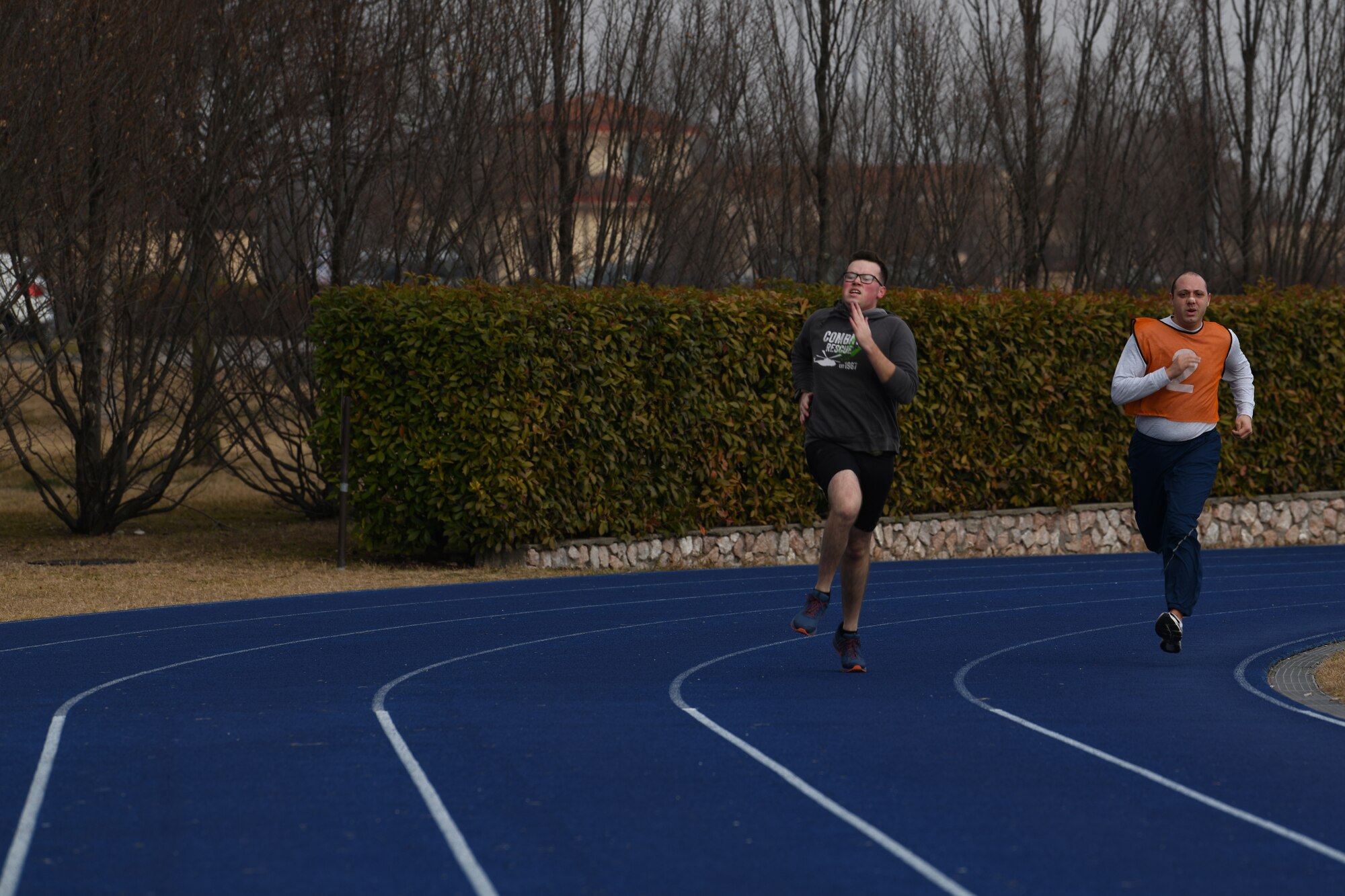 U.S. Air Force Airman 1st Class Dale Riehl, 31st Aircraft Maintenance Squadron, 56th Helicopter Maintenance Unit, sprints with an Airman during his physical fitness assessment at Aviano Air Base, Italy, Jan. 27, 2019. Riehl is a physical training leader and makes it his goal to motivate any Airmen that he can during their physical fitness assessment. (U.S. Air Force photo by Airman 1st Class Ericka A. Woolever)