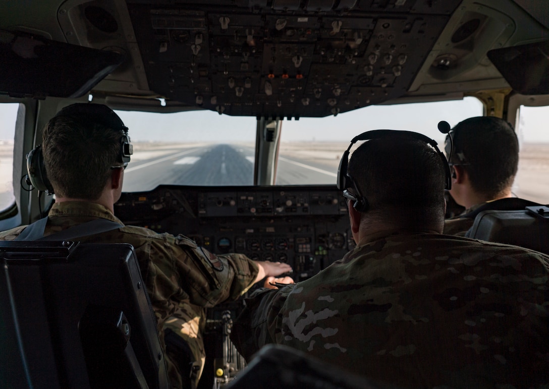 A U.S. Air Force pilot, left, a U.S. Air Force flight engineer, center, and U.S. Air Force co-pilot, assigned to the 908th Expeditionary Air Refueling Squadron,  perform takeoff procedures aboard a KC-10 Extender at Al Dhafra Air Base, United Arab Emirates, Jan. 22, 2020.