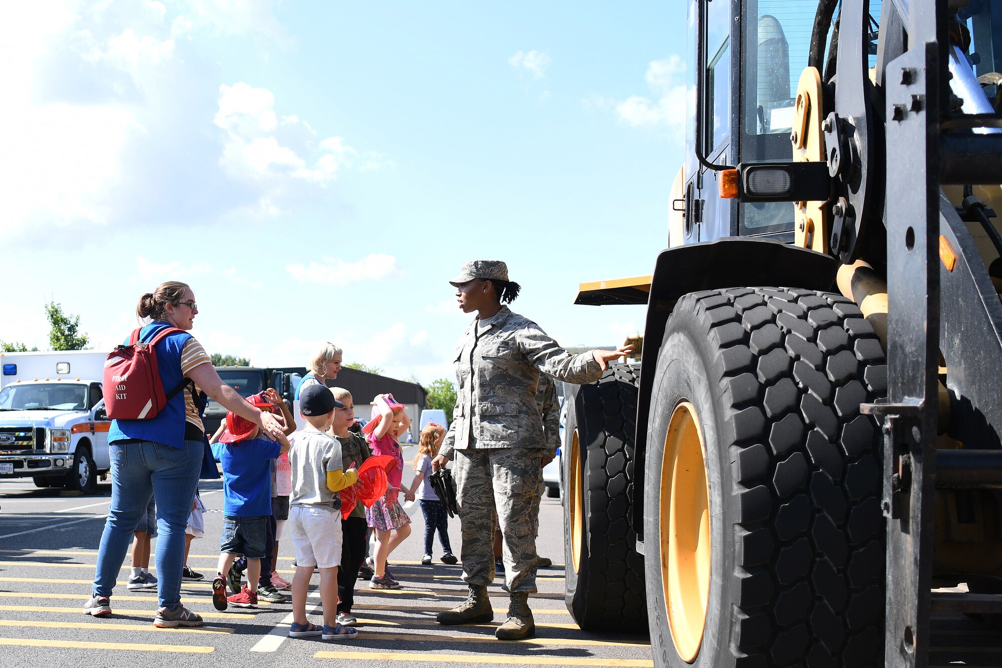 A Child and Youth Program provider ushers children through an interactive vehicle display hosted by the 48th Logistic Readiness Squadron at Royal Air Force Lakenheath, England, 03 July 2019. Recently, approximately 250 providers had the opportunity network with Liberty Wing helping agencies to enhance their education in various areas of childcare.  (U.S. Air Force photo by Senior Airman Shanice Williams-Jones)