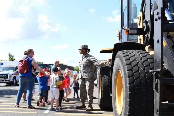 A Child and Youth Program provider ushers children through an interactive vehicle display hosted by the 48th Logistic Readiness Squadron at Royal Air Force Lakenheath, England, 03 July 2019. Recently, approximately 250 providers had the opportunity network with Liberty Wing helping agencies to enhance their education in various areas of childcare.  (U.S. Air Force photo by Senior Airman Shanice Williams-Jones)