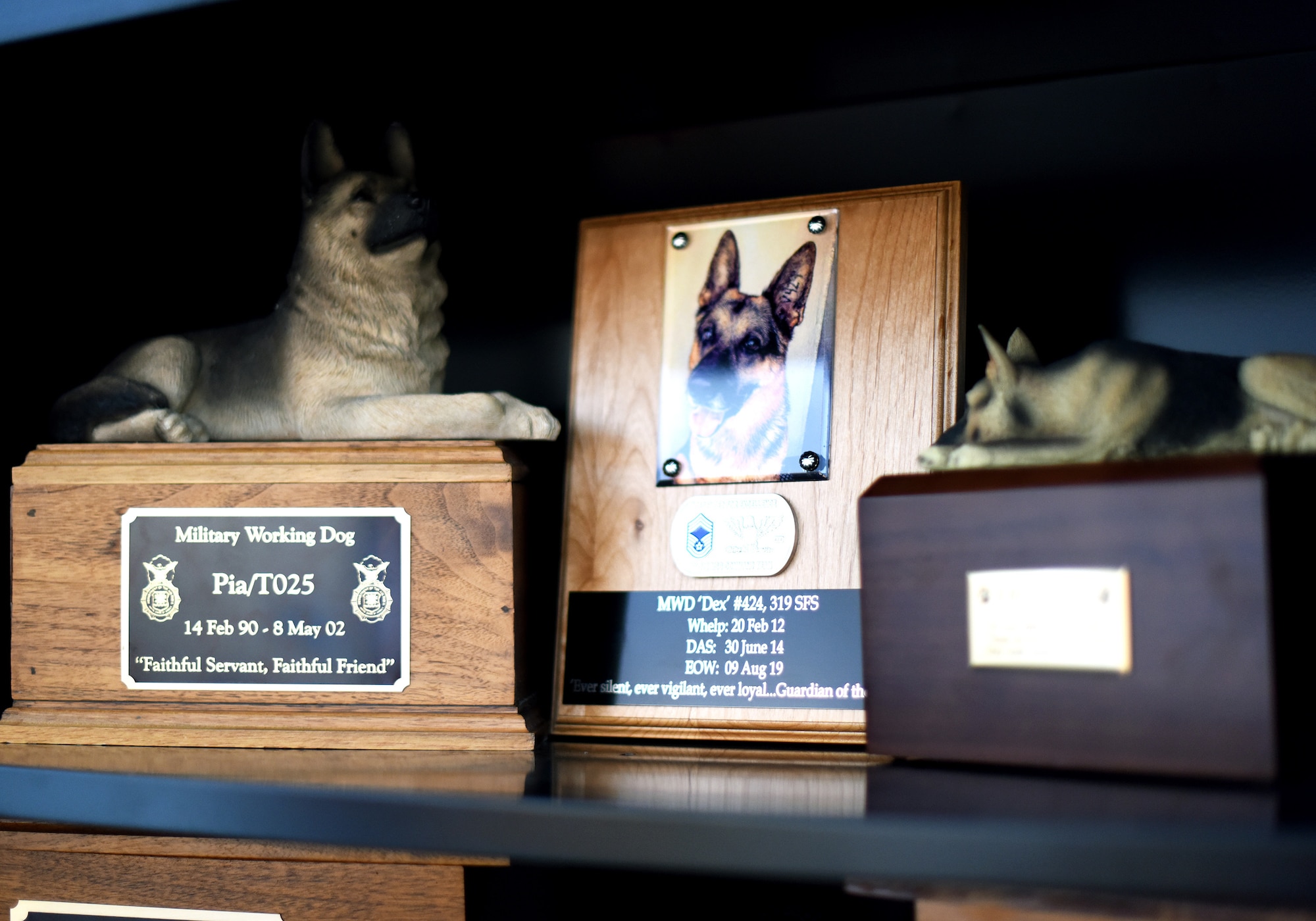 Memorials to 319th Security Forces Squadron military working dogs Pia, left, and Dex, center, are displayed during for the grand-opening of a new K-9 facility at Grand Forks Air Force Base, N.D., Jan. 24, 2020. The new facility will significantly improve the work environment for MWD’s and their handlers. (U.S. Air Force photo by Staff Sgt. Patrick A. Wyatt)