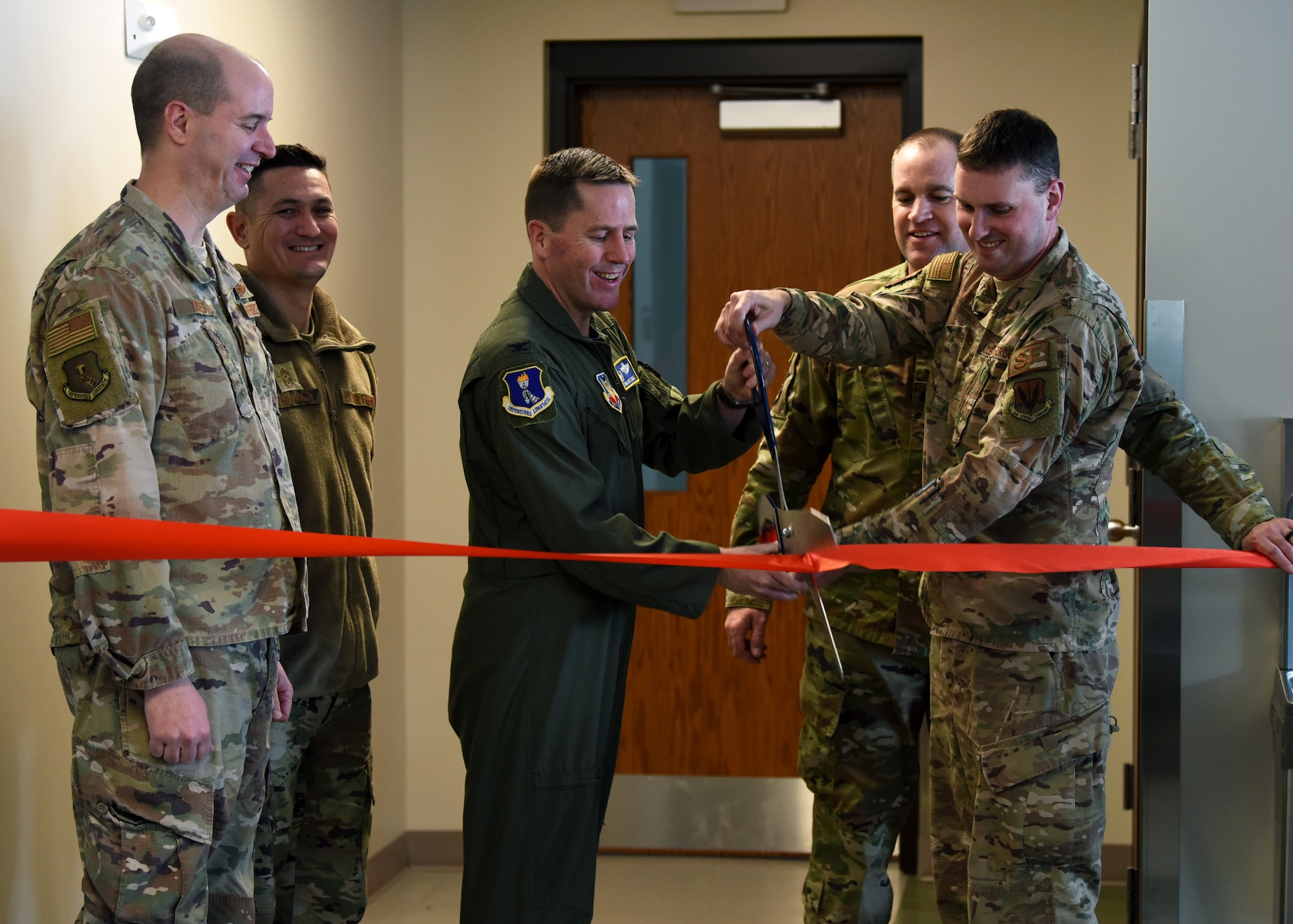 Col. Cameron Pringle, 319th Reconnaissance Wing commander, center, and Col. Chad Atkinson-Adams, 319th Security Forces Squadron commander, cut a ribbon during the grand-opening of a new K-9 facility at Grand Forks Air Force Base, N.D., Jan. 24, 2020. The six-year project cost an estimated $2.1 million. (U.S. Air Force photo by Staff Sgt. Patrick A. Wyatt)