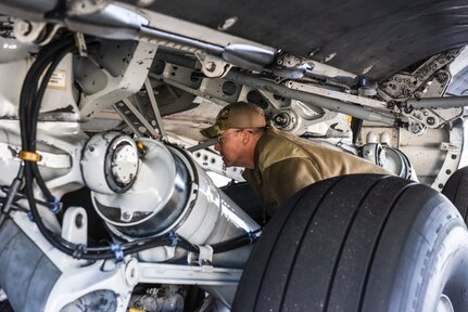 Brig. Gen. Richard W. Gibbs, Air Mobility Command Logistics, Engineering and Force Protection director, examines the underside of a C-17 Globemaster III at Joint Base Charleston, S.C., Jan. 28, 2020.
