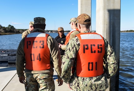 Team Charleston leadership listen to a briefing  after a ride-along in a harbor security patrol boat at Joint Base Charleston, S.C., Jan. 28, 2020.