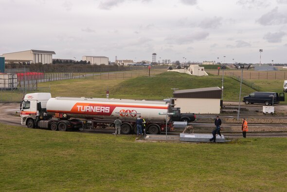 Airmen of the 100th Logistics Readiness Squadron fuel management flight and employees from the Defense Logistics Agency prepare to unload fuel from a tanker truck Jan. 27, 2020, at RAF Mildenhall, England. The transfer of fuel from an off-base supplier to underground storage facilities on base is performed annually to verify if fuel can be received through an alternate method during a contingency response situation. (U.S. Air Force photo by Airman 1st Class Joseph Barron)