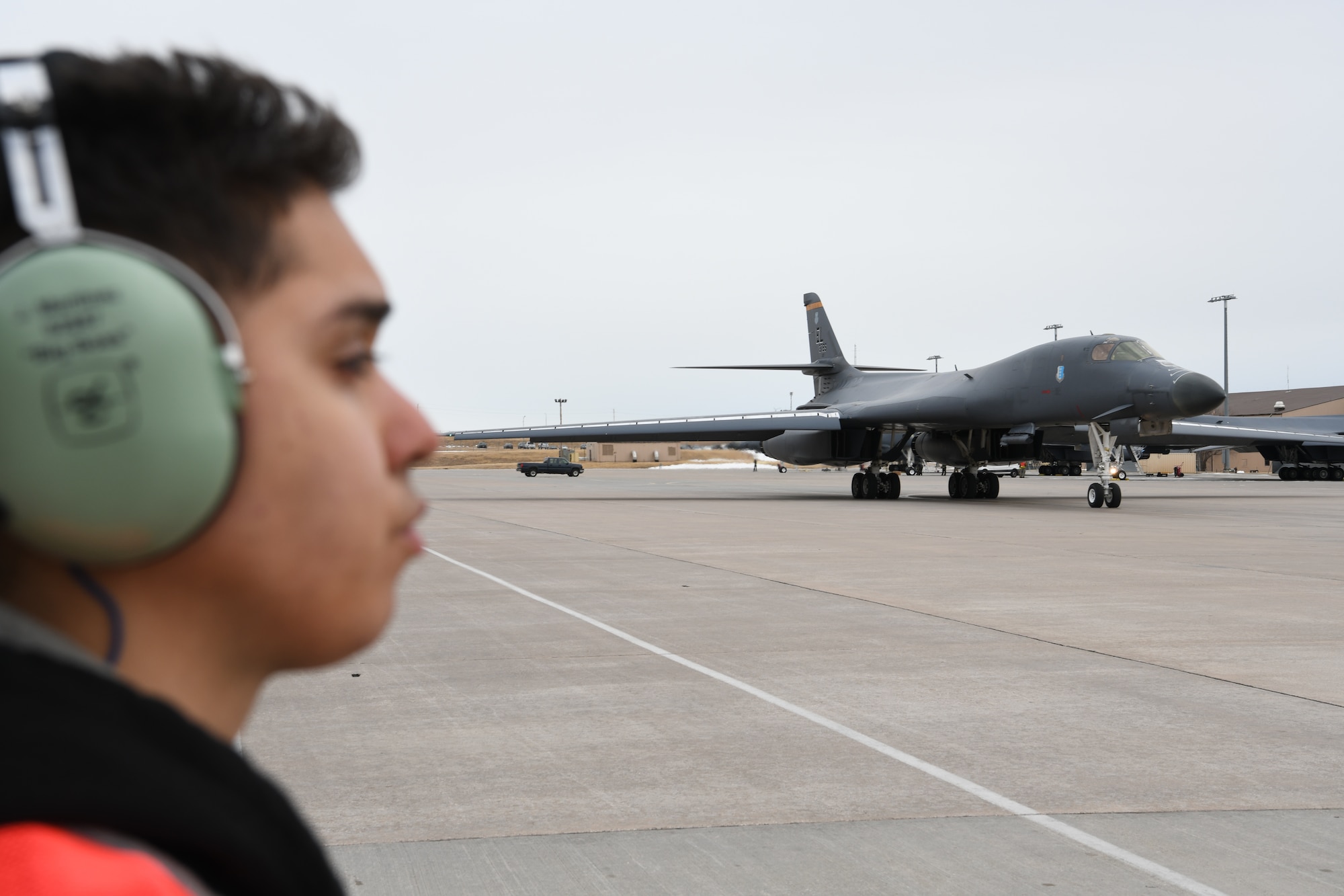 Airman Jacob Martinez, a 37th Bomb Squadron crew chief, waits as a B-1B Lancer taxis at Ellsworth Air Force Base, S.D., Jan. 22, 2020. The mission of Red Flag is to maximize the combat readiness and survivability of participants by providing multi-domain training in a combined threat environment. (U.S. Air Force photo by Senior Airman Nicolas Z. Erwin)