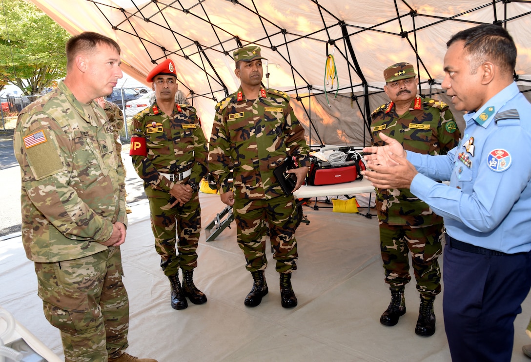 Soldiers speak in a tent.