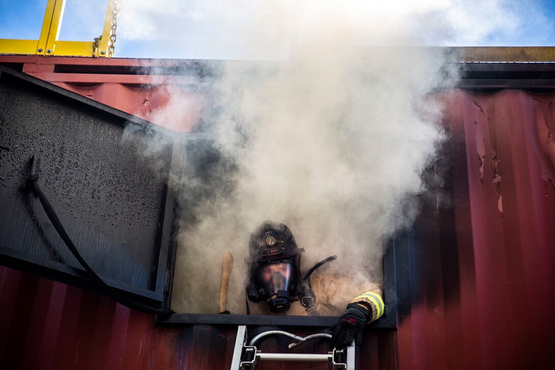 A firefighter with the San Marcos Fire Department signals to another firefighter to climb up a ladder during a joint structural firefighting exercise at Marine Corps Base Camp Pendleton, California, Jan. 28, 2020. The Camp Pendleton Fire Department regularly hosts a variety of training exercises to strengthen their partnerships and cohesion with fire departments from surrounding communities in preparation for the annual wildfire season. (U.S. Marine Corps photo by Cpl. Dylan Chagnon)