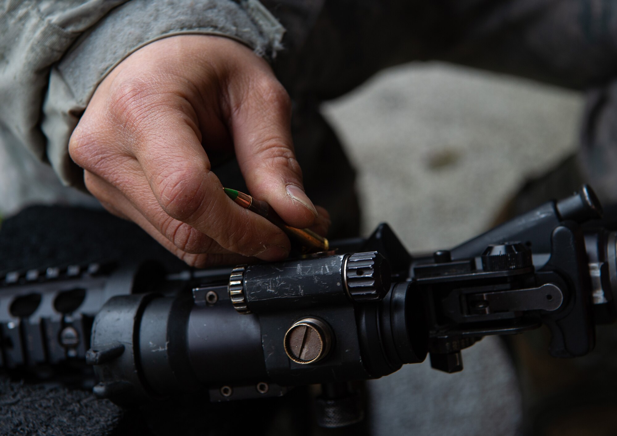 Staff Sgt. Dan Antonio Deladingco, 627th Security Forces Squadron combat arms instructor, adjusts the sights for a M-4 rifle for a student during a qualification course at Joint Base Lewis-McChord, Wash., Jan. 23, 2020. Combat arms is one of three missions for the 627th SFS, which also includes flight line security and protecting aircraft in austere environments through the Phoenix Raven program. (U.S. Air Force photo by Senior Airman Tryphena Mayhugh)