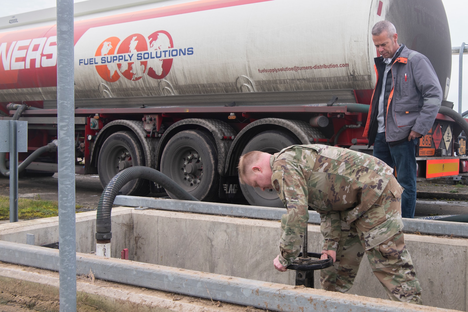 Master Sgt. Joseph Feiss, 100th Logistics Readiness Squadron noncommissioned officer in charge of fuels environmental safety office, closes the valves to underground fuel tanks as Mike Wilson, Defense Logistics Agency quality assurance representative, watches Jan. 27, 2020, at RAF Mildenhall, England. Petroleum, oil and lubricants Airmen from RAF Mildenhall power the only aerial refueling wing for United States Air Forces in Europe and Air Forces Africa. (U.S. Air Force photo by Airman 1st Class Joseph Barron)