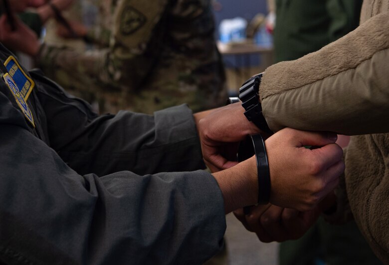 A student of the 627th Security Forces Squadron (SFS) Phoenix Raven’s instruction course for how to properly process and hold detainees practices handcuffing a simulated detainee at Joint Base Lewis-McChord, Wash., Dec. 5, 2019. Phoenix Ravens are one of three missions for the 627th SFS, which also includes flight line security and instructing Airmen on firearms and weapons handling through combat arms. (U.S. Air Force photo by Senior Airman Tryphena Mayhugh)