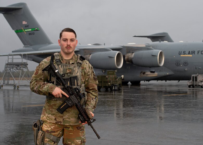 Staff Sgt. Brandon Grimes, 627th Security Forces Squadron (SFS) response team leader, stand in front of a C-17 Globemaster III at Joint Base Lewis-McChord, Wash., Dec. 12, 2019. Flight line security is one of three mission sets for the 627th SFS, which also protects aircraft in austere environments through the Phoenix Raven program and instructs Airmen on firearms and weapons handling through combat arms. (U.S. Air Force photo by Senior Airman Tryphena Mayhugh)
