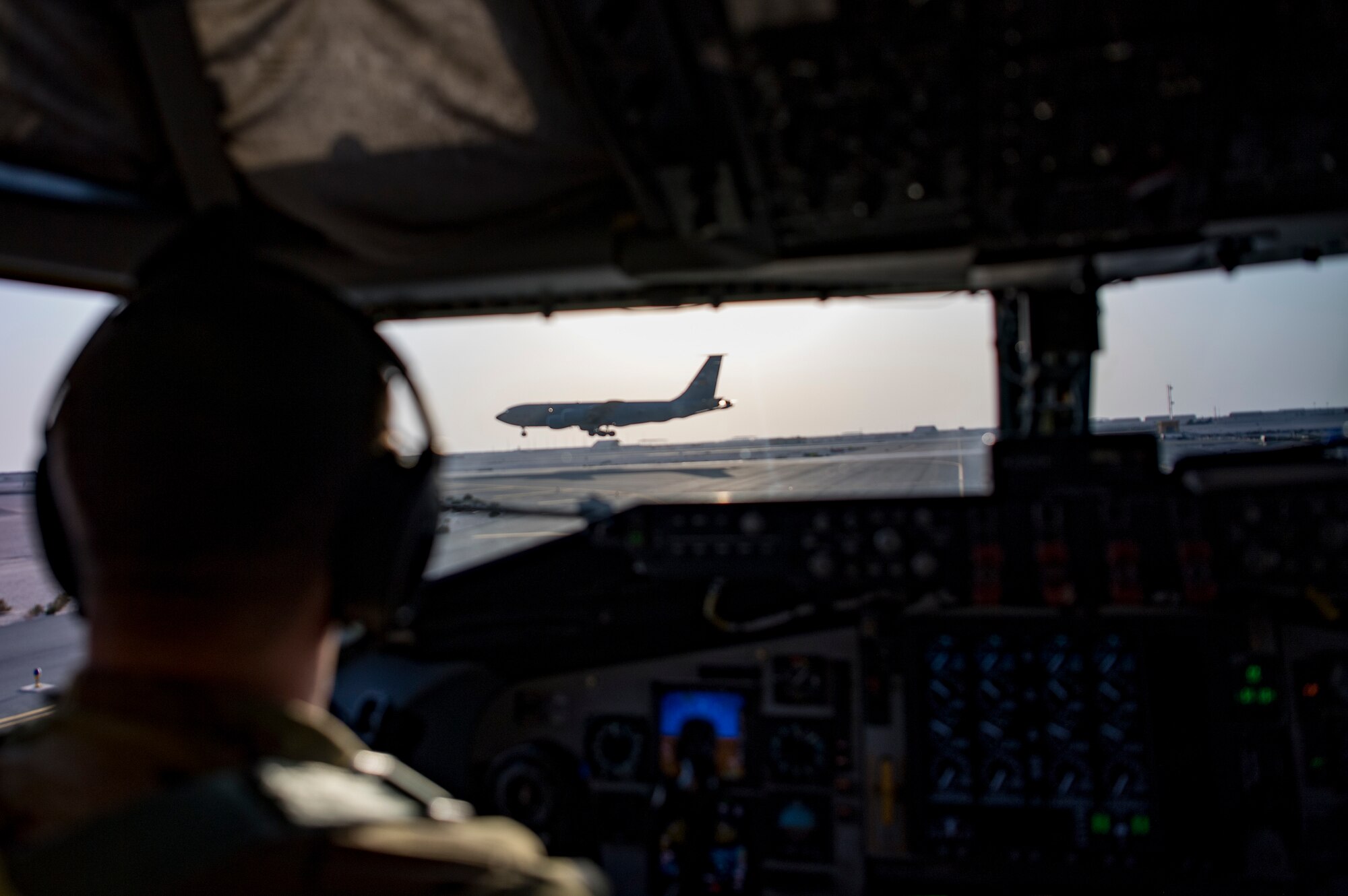 A U.S. Air Force KC-135 Stratotanker pilot assigned to the 28th Expeditionary Air Refueling Squadron watches A KC-135 takeoff at Al Udeid Air Base, Qatar, Jan. 3, 2020.