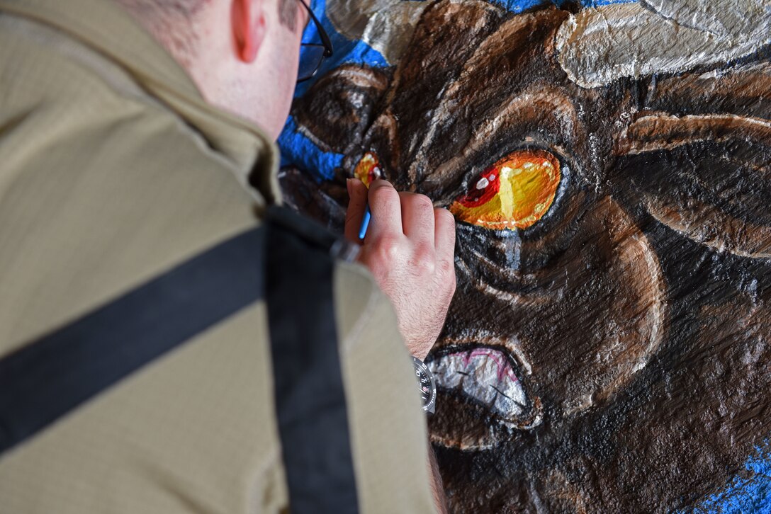 U.S. Air Force Capt. William Steers, 31st Civil Engineer Squadron, paints a spirit rock at Aviano Air Base, Italy, Jan. 30, 2020. The 31st CES later delivered the spirit rock and placed it in front of the 31st Fighter Wing headquarters building.
