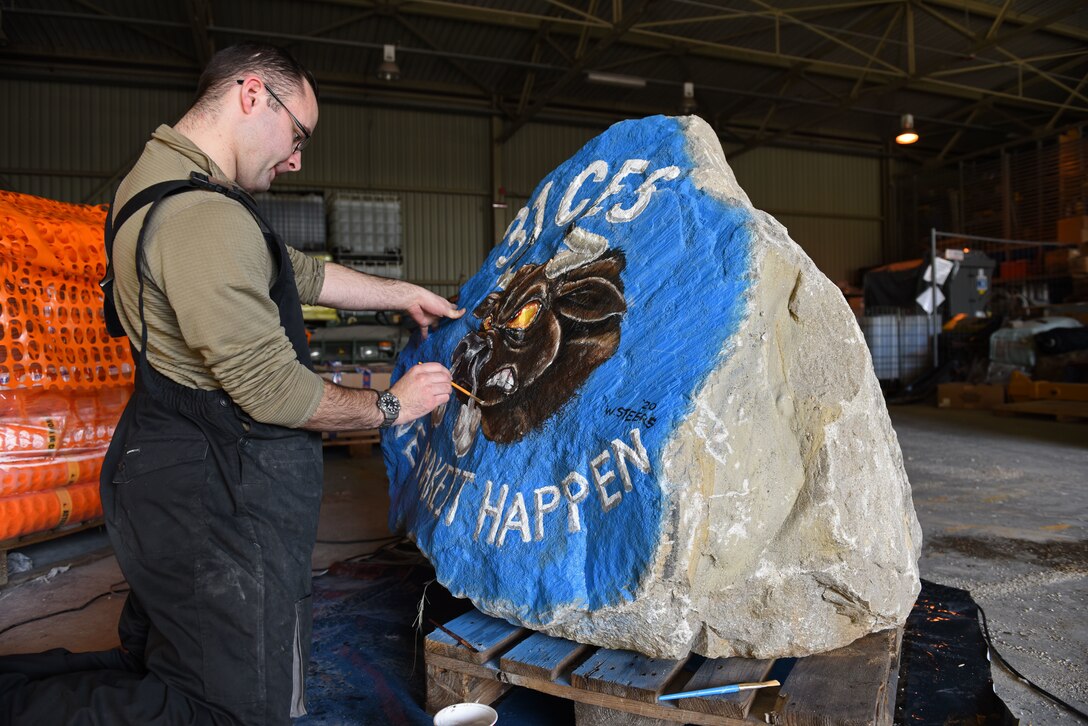 U.S. Air Force Capt. William Steers, 31st Civil Engineer Squadron, paints a spirit rock at Aviano Air Base, Italy, Jan. 30, 2020. The 31st CES later delivered the spirit rock and placed it in front of the 31st Fighter Wing headquarters building.