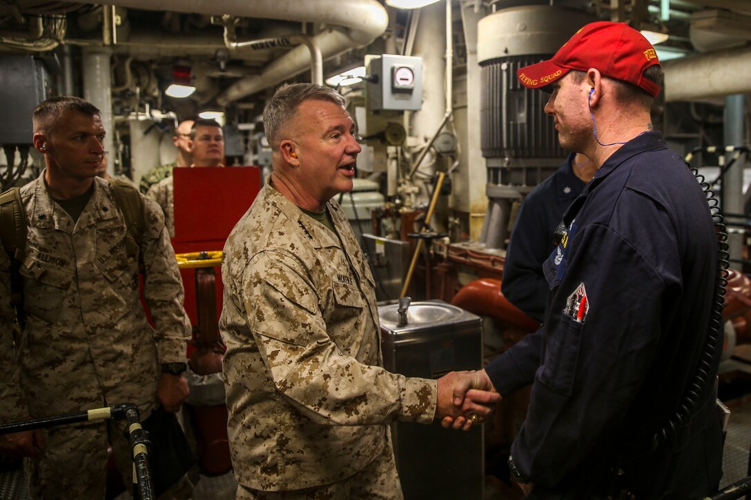 Gen. Kenneth F. McKenzie Jr., commander of U.S. Central Command, shakes the hand of a Sailor while touring the main machinery room onboard the amphibious assault ship USS Bataan (LHD 5). Bataan Amphibious Ready Group, with embarked 26th Marine Expeditionary Unit, is deployed to the U.S. 5th Fleet area of operations in support of maritime security operations to reassure allies and partners and preserve the freedom of navigation and the free flow of commerce in the region. (U.S. Marine Corps photo by Cpl. Tanner Seims)