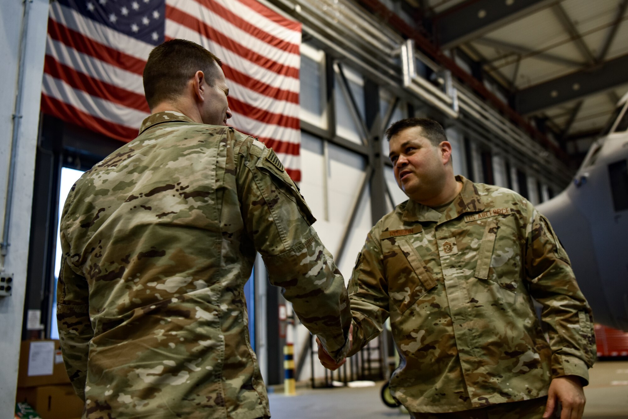 U.S. Air Force Chief Master Sgt. Ernesto Rendon, 86th Airlift Wing command chief (right), coins Master Sgt. Hollie McCaleb, 86th Maintenance Squadron C-130J inspections section chief, at Ramstein Air Base, Germany, Jan. 14, 2020. McCaleb developed new quality assurance processes that saved over 1,400 man hours per year.