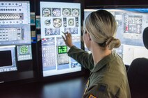 Navigator U.S. Air Force Capt. Alexandria Anzur prepares her station in the sim for a flight.