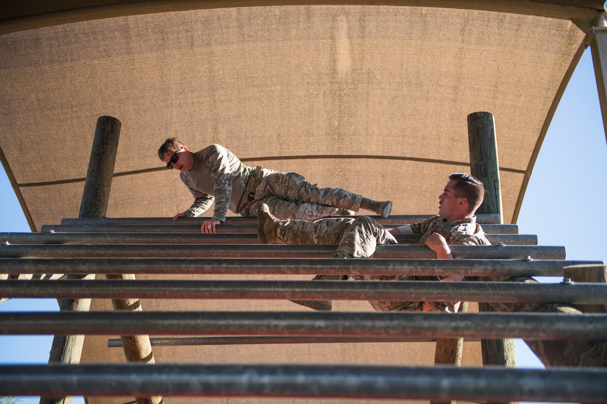 U.S. Air Force Senior Airman Paul Cupp (left), 42nd Security Forces Squadron, Maxwell-Gunter Air Force Base, Ala., and Senior Airman Andrew Vance, 902nd Security Forces Squadron military working dog handler, Joint Base San Antonio-Randolph, take part in the obstacle course portion of the Air Education and Training Command Defender Challenge team tryout at Joint Base San Antonio-Medina Annex, Texas, Jan. 29, 2020. The five-day selection camp includes a physical fitness test, M-9 and M-4 weapons firing, the alpha warrior obstacle course, a ruck march and also includes a military working dog tryout as well. A total of 27 Airmen, including five MWD handlers and their canine partners, were invited to tryout for the team. The seven selectees to the AETC team will represent the First Command at the career field’s world-wide competition that will be held at JBSA-Camp Bullis in May 2020. (U.S. Air Force photo by Sarayuth Pinthong)