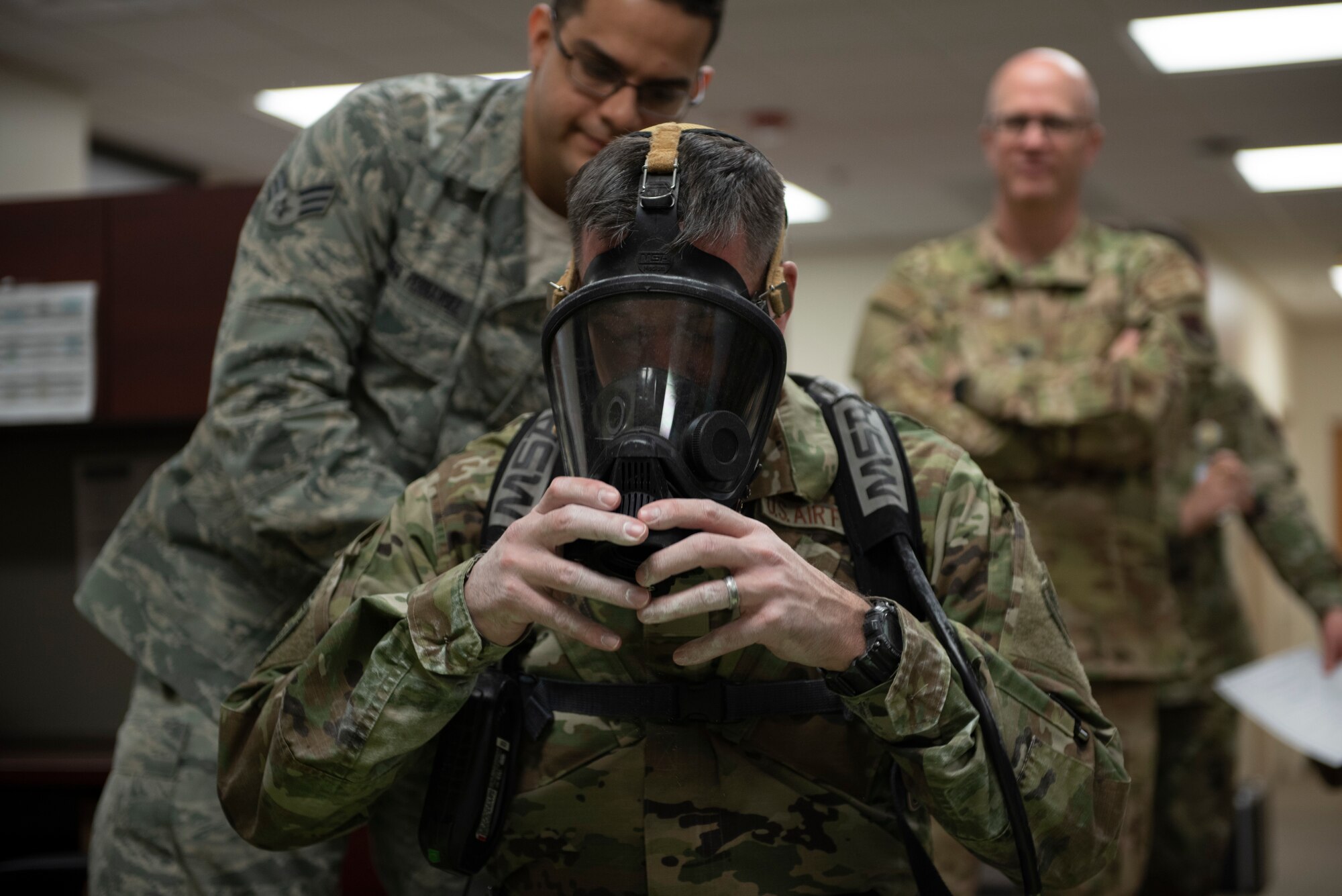 A photo of leadership putting on a breathing apparatus during an immersion tour.