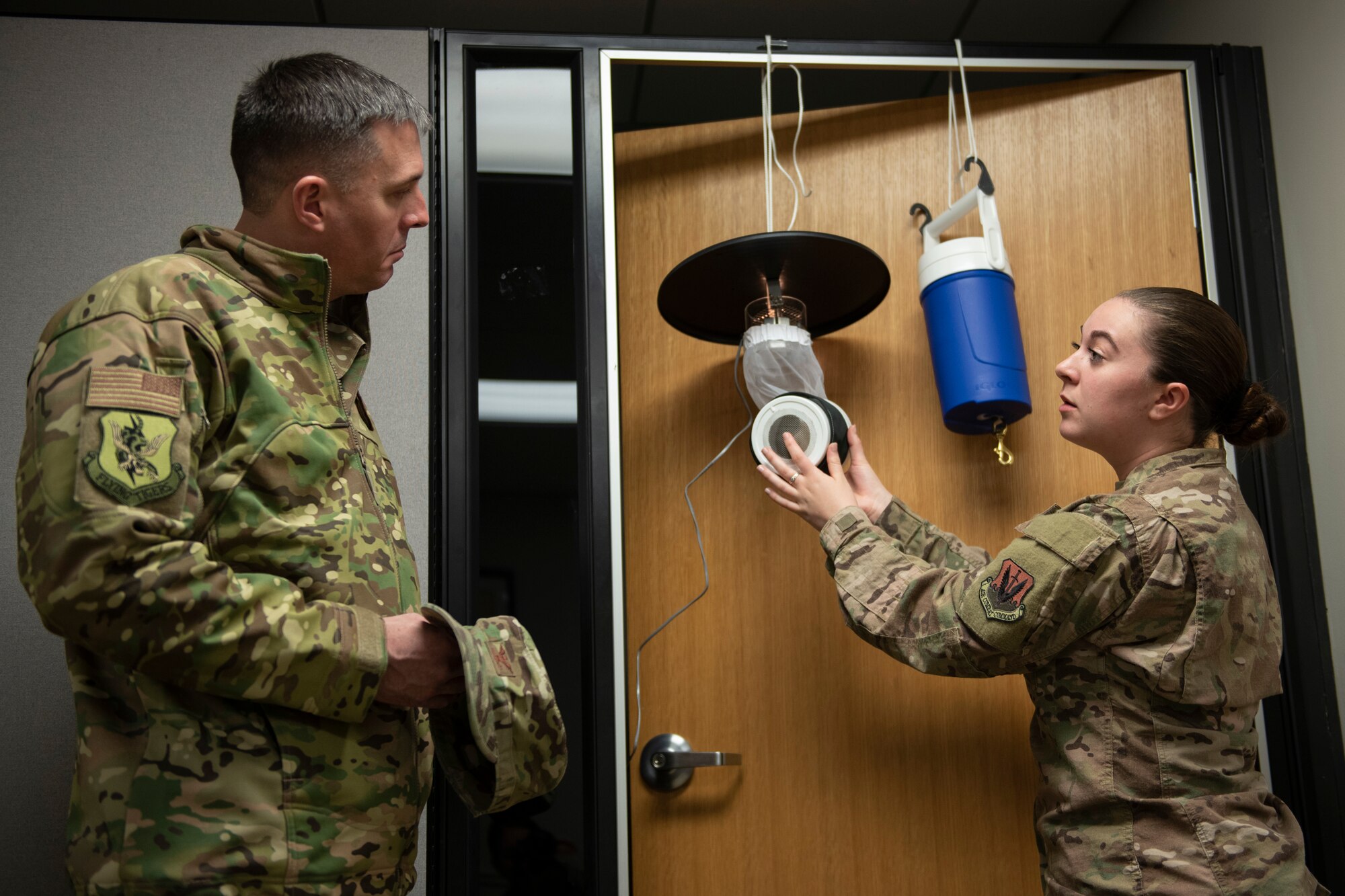 A photo of an Airman explaining the importance of mosquito traps to leadership.