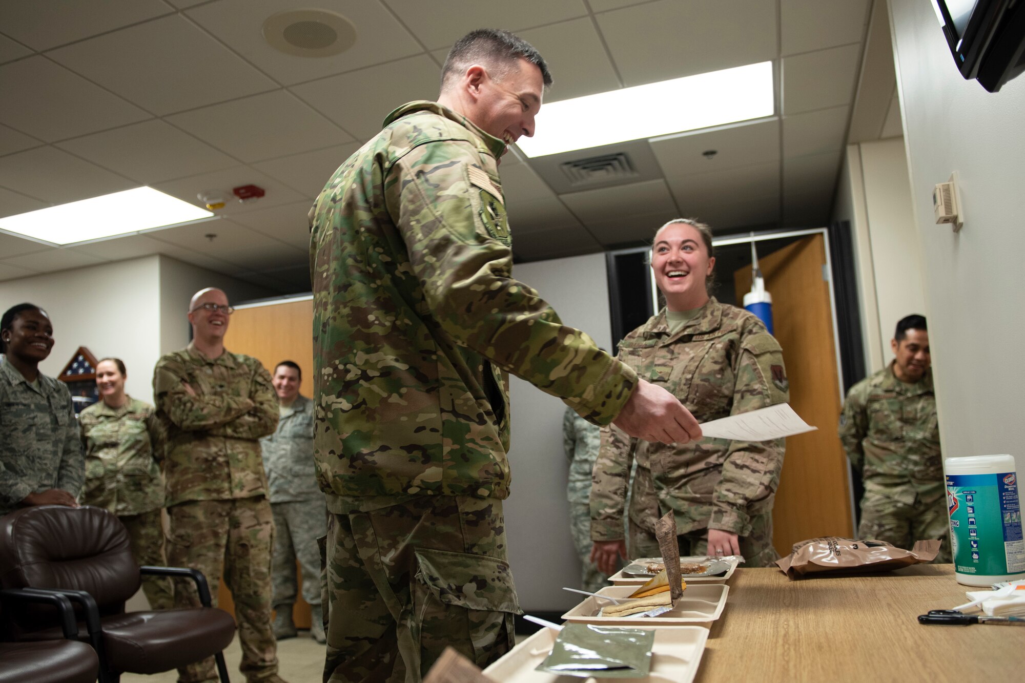 A photo of an Airman explaining how to inspect Meals, Ready to Eat to leadership.